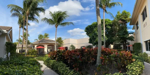 A large building with palm trees in the background.